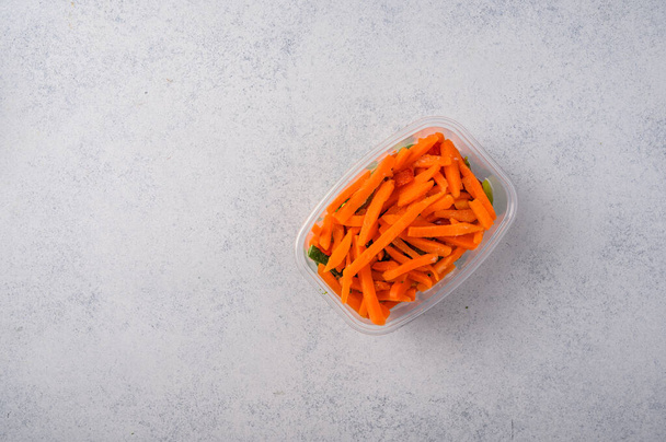 Frozen vegetables carrot in a plastic tray on an gray background top view - Photo, Image