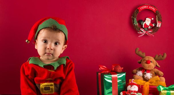 Sweet one-year-old boy dressed as an elf, in Christmas decoration, with gifts - Photo, Image