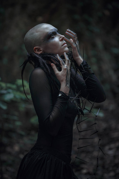Beautiful young bald woman portrait outdoors. spiritual concept. Witch in black. Makeup and character for Halloween. - Фото, зображення