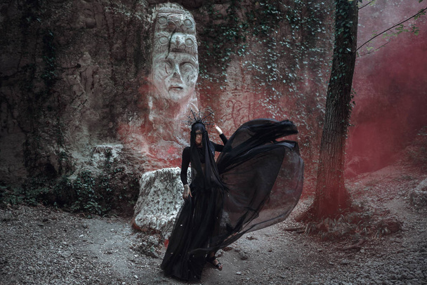 Fantasy donna horror strega in abito nero. Ritratto magico gotico. Evil viso trucco Art spaventoso, Mago incantesimo pesante fumo rosso. - Foto, immagini