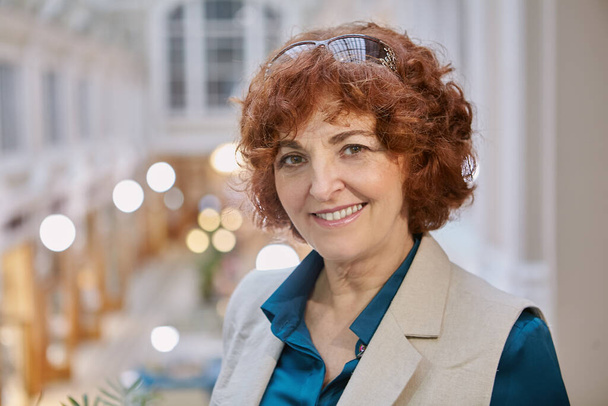 Portrait of a smiling mature woman of European appearance inside a shopping mall. - Fotoğraf, Görsel