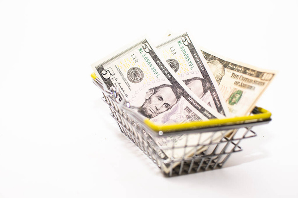 American money (dollars) is in a small grocery basket on a white background. - Zdjęcie, obraz