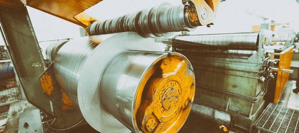 Rolled steel. Stack of rolls, cold rolled steel coils in action. Galvanized steel sheet and rusted edge. Cold rolled steel coils. Drum turns sheets into production. Industrial - Photo, Image