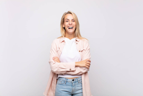 Woman looking like a happy, proud and satisfied achiever smiling with arms crossed - Фото, изображение