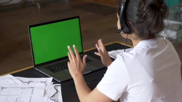Egy ázsiai nő válla fölött, aki zöld vásznat néz. Irodai személy használja laptop számítógép zöld képernyővel - Felvétel, videó
