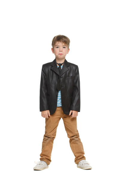 Little cute boy in a jacket stands in full growth isolated on a white background. - Fotó, kép