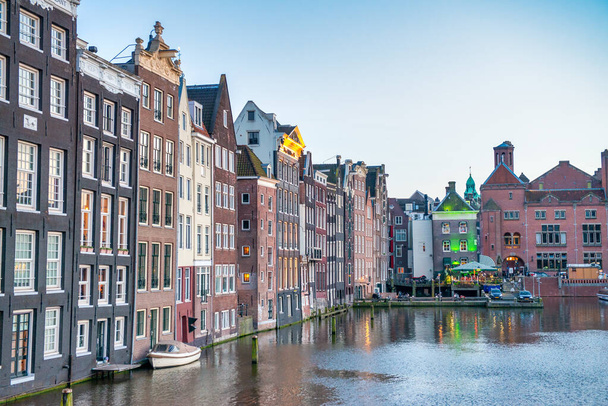 Κλασικά κτίρια του Άμστερνταμ κατά μήκος των καναλιών της πόλης σε ένα ηλιόλουστο απόγευμα, Ολλανδία. - Φωτογραφία, εικόνα