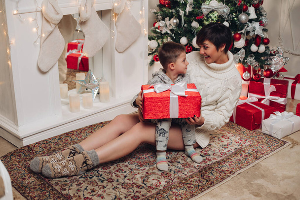 Onnelliset vanhemmat osoittavat joulukoristeen pienelle pojalle. - Valokuva, kuva