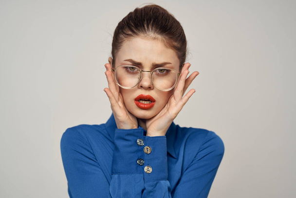 Portrét emocionální ženy v modré košili a brýle jasný make-up model světlo pozadí oříznutý pohled kopírovat prostor - Fotografie, Obrázek