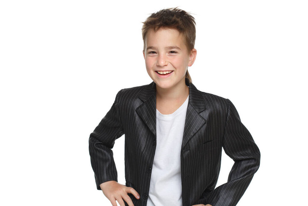 Little laughing boy in a jacket hands on belt isolated on a white background. - Foto, afbeelding