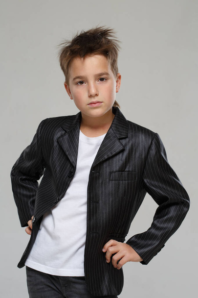Little stylish boy in a jacket isolated on a gray background. - 写真・画像