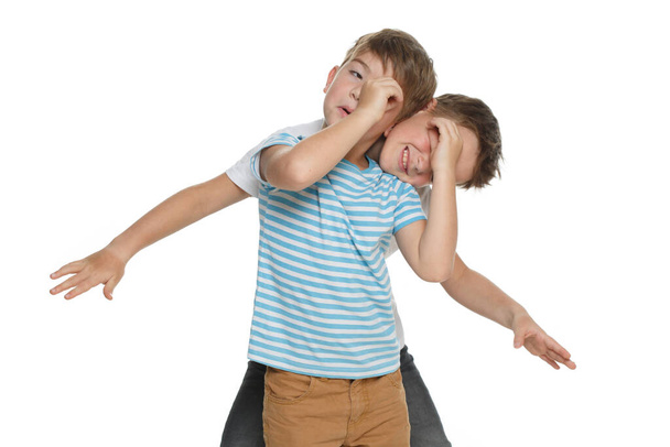 Two little funny boys indulging Isolated on a white background. - Foto, afbeelding