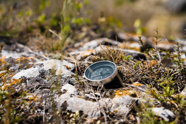 The compass lies on a picturesque mountain rock with moss - Photo, Image