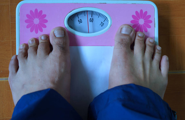 Foot on the weight scale, health and weight management concept. - Photo, Image