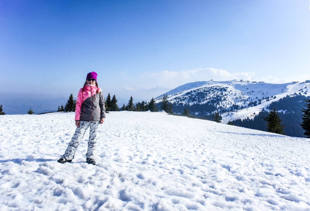 Jeune femme souriante sur la piste de ski enneigée de Kopaonik en tenue de ski. Mode de vie actif - Photo, image