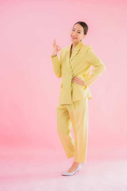 Muotokuva kaunis nuori aasialainen liike nainen hymy toiminnassa vaaleanpunainen väri tausta - Valokuva, kuva