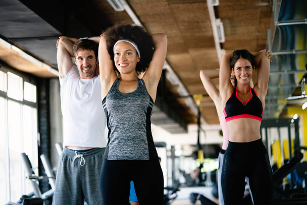 Diversity group of people training in a gym. Trainer and sportive fit persons exercising in a fitness class - Fotoğraf, Görsel