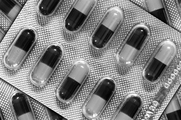Капсулы для лекарственных целей в блистерных упаковках крупным планом черно-белого цвета - Фото, изображение