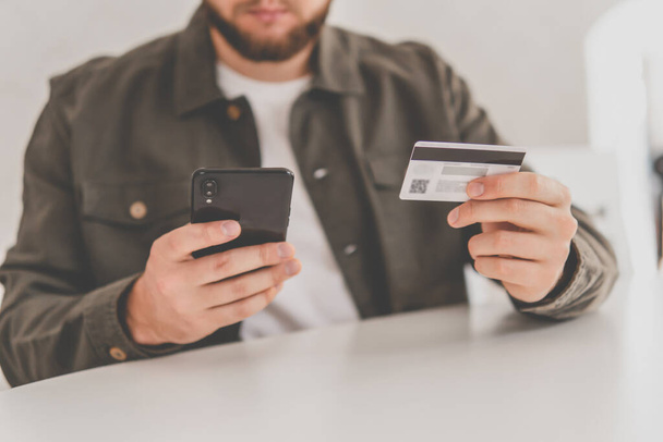 payment online shopping smartphone at working place. Buying online with a credit card and smart phone sitting home with a blurred background. hand credit card for shopping online. Web shopping . - Photo, Image