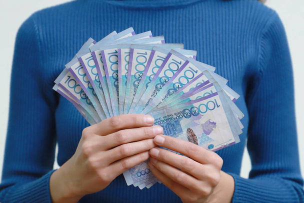 Kazachstan geld tenge tegen de achtergrond van een persoon. De nominale waarde is tienduizend. - Foto, afbeelding