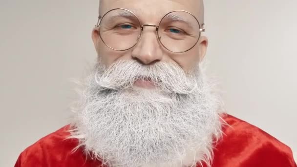 Portret twarzy uśmiechniętego Świętego Mikołaja, radosny wyraz twarzy patrzący w kamerę - Materiał filmowy, wideo