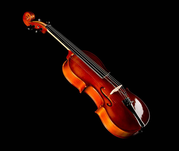 Brown wooden fiddle or violin, classic musical instrument, isolated over black background, selective focus - Photo, image