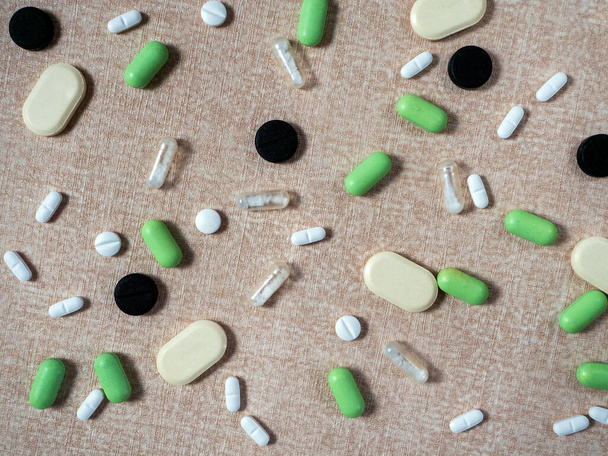 Bézs háttér gyógyszerek külön-külön. Orvosi háttér tabletták a különböző betegségek, különböző formák és színek. - Fotó, kép