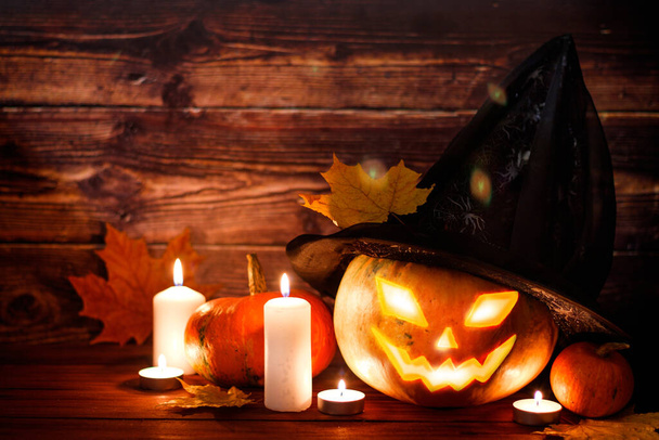 Happy Halloween! Pumpkin in a witch hat on a wooden background. Place for text. - Photo, Image