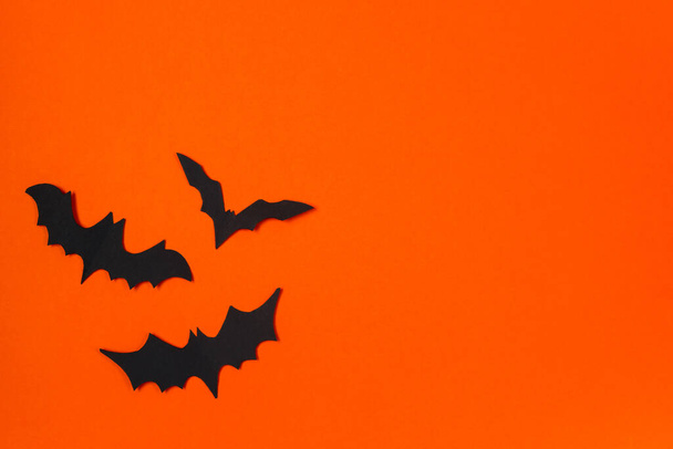 Концепция Хэллоуина. Праздничные украшения. Летучие мыши на оранжевом фоне. - Фото, изображение
