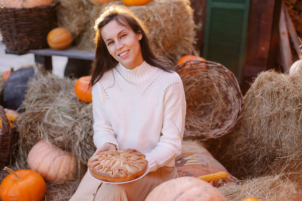 housewife holding homemade delicious pie for Thanksgiving. A woman is waiting for guests of family traditions. festive dinner treat. Girl happy smiling autumn portrait. country house  veranda outside - Фото, зображення