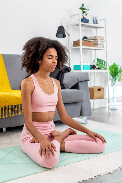 Afroamerykanka praktykująca lotos do jogi pozowała do medytacji w przytulnym domu - Zdjęcie, obraz