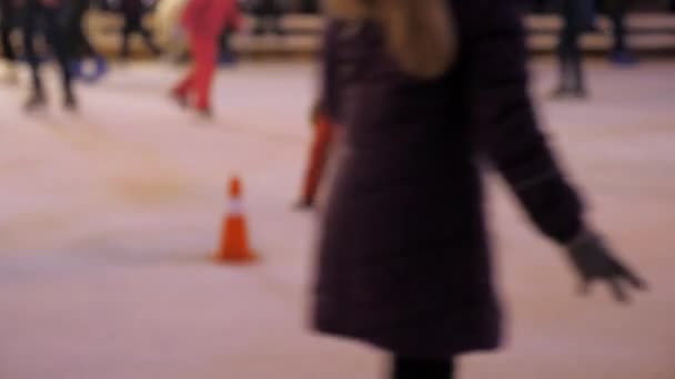 Defocus. Férfi nők a gyerekek télen jégen korcsolyáznak. Amatőr sportolók - Felvétel, videó