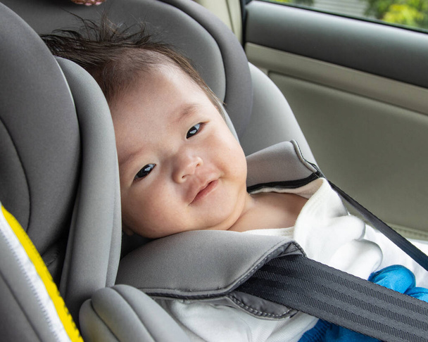 Style de vie local Asiatique Chinois bébé garçon heureux sourire blanc assis sur le siège auto de sécurité enfant - Photo, image