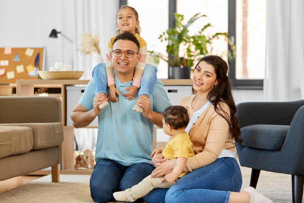 portrait of happy family sitting on sofa at home - Φωτογραφία, εικόνα