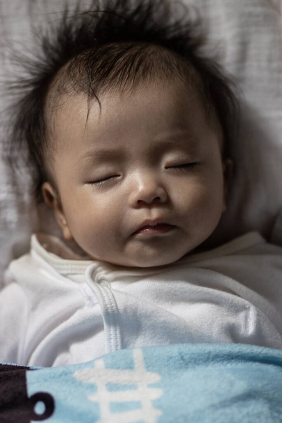 Маленька азіатська китайська дитина спить удома. - Фото, зображення
