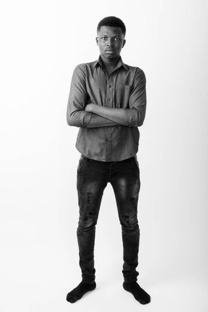 Studio shot of young African businessman against white background in black and white - Fotoğraf, Görsel