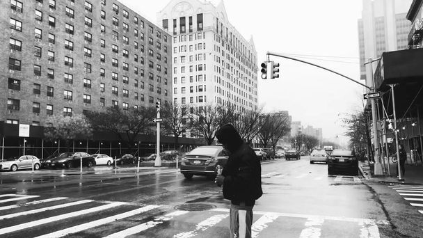 NUEVA YORK CITY - DICIEMBRE 2018: Las calles de Harlem en un día lluvioso con gente y tráfico. Movimiento lento - Foto, Imagen