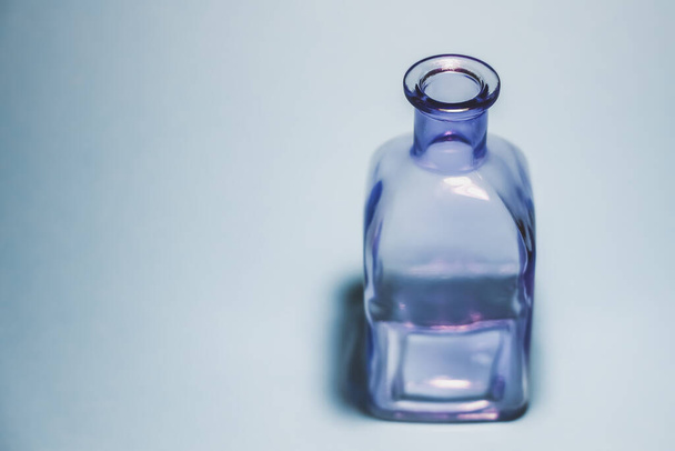 Purple empty glass bottle on the background with free copy space - Photo, image