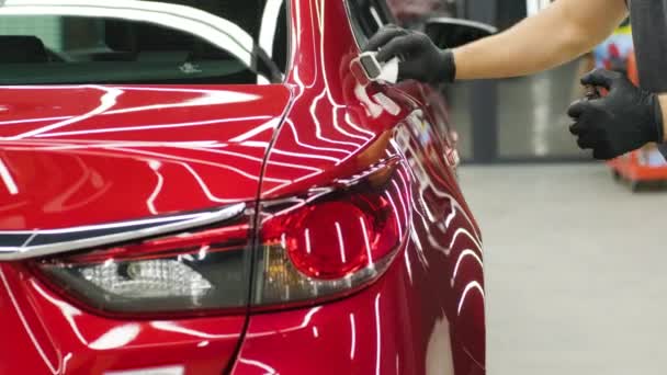 Autoservice-Mitarbeiter trägt Nano-Beschichtung auf ein Detail im Auto auf. - Filmmaterial, Video