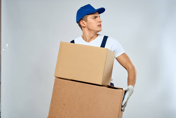 werkende man in uniform met dozen in zijn handen levering lader levensstijl - Foto, afbeelding