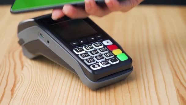 Απεριόριστη πληρωμή με smartphone με πράσινη οθόνη mock-up. Ασύρματη έννοια πληρωμής. Κοντινό πλάνο, γυναίκα που χρησιμοποιεί το smartphone χωρίς μετρητά τεχνολογία πορτοφόλι NFC για να πληρώσει την παραγγελία στο τερματικό τράπεζα. - Πλάνα, βίντεο