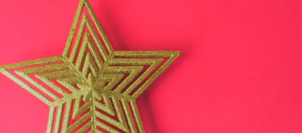 Golden star representing christmas, on red background and space for text - Photo, Image