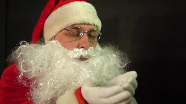 Święty Mikołaj wieje brokat z rąk w zwolnionym tempie. - Materiał filmowy, wideo