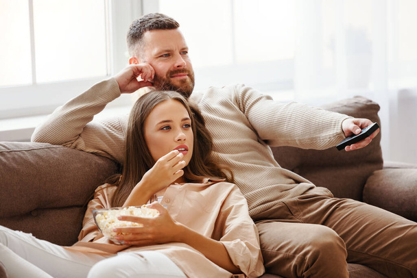 Family couple watching television at home on the sof - Fotoğraf, Görsel