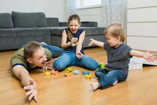A család a padlón játszik a szobában. Boldog családi koncepció. - Fotó, kép