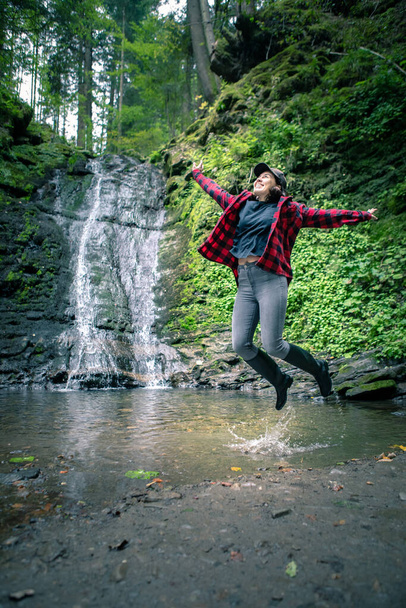 young hiking woman looking at waterfall copy space - Photo, Image