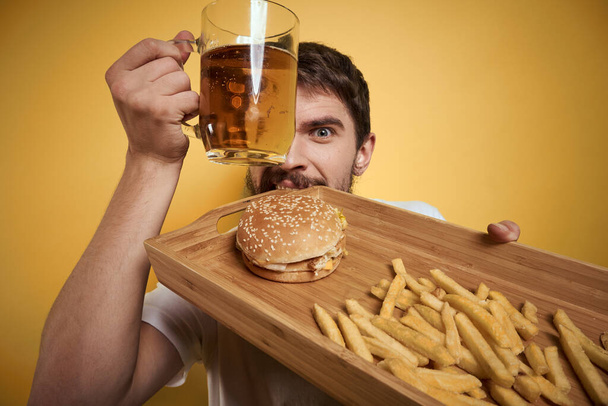 Bearded man with mug of beer fast food diet food fun alcohol lifestyle yellow background - Photo, Image