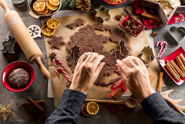 partial view of man making festive Christmas gingerbread cookies. - Foto, afbeelding