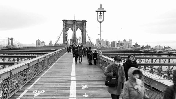НЬЮ-ЙОРК - ДЕКАБРЬ 2018: Машины и люди, идущие по Бруклинскому мосту из Манхэттена и Бруклина. Медленное движение - Фото, изображение