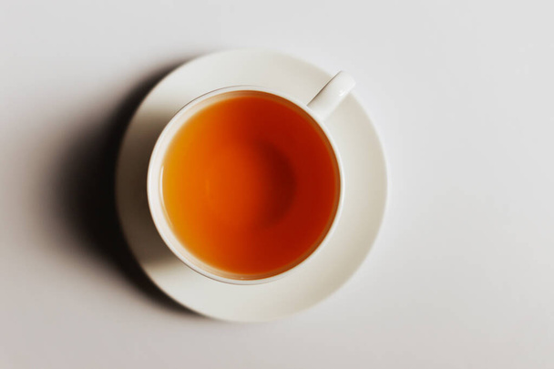 taza de té sobre fondo blanco. taza blanca con un té aislado en un fondo blanco. vista superior. - Foto, imagen